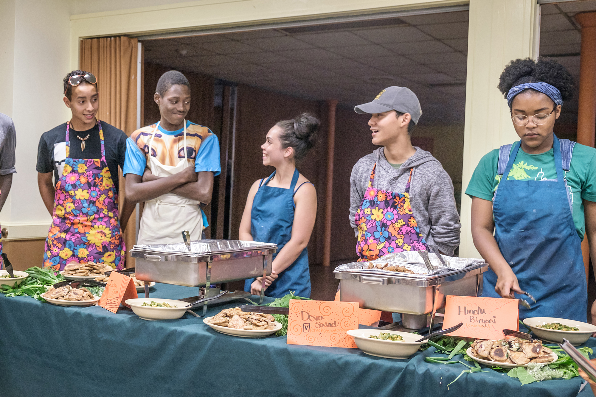 volunteers standing behind a table ready to serve food