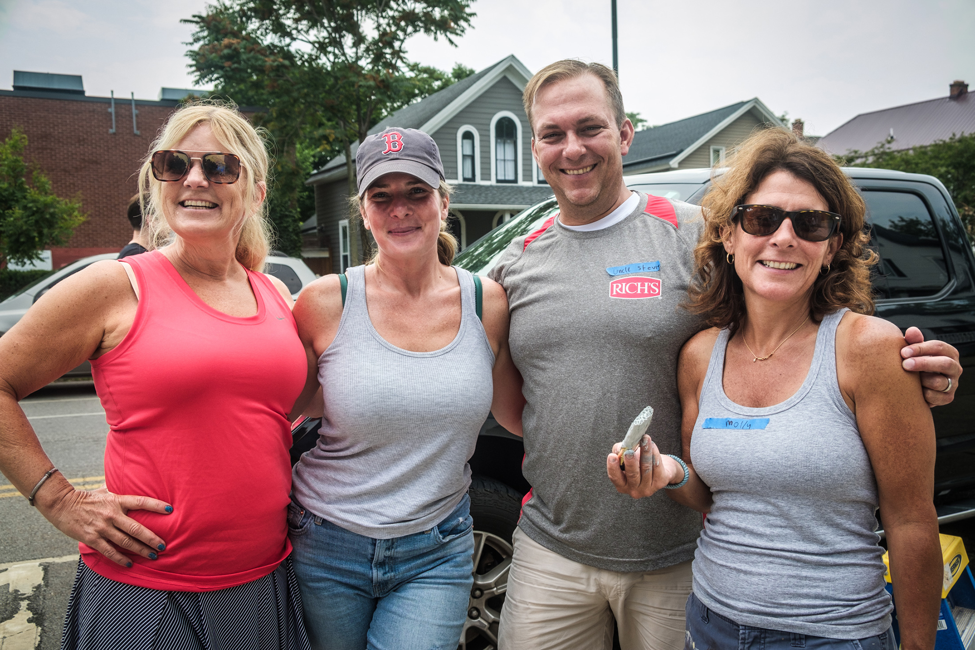 group of people standing on the sidewalk posing for their photo